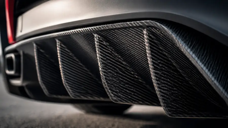 Close Up Low Angle View of a Woven Carbon Fiber Rear Diffuser Fins 4K wallpaper for desktop and mobile - Pixbee