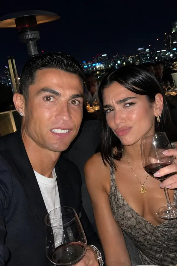 “Cristiano Ronaldo enjoying the rooftop dinner while Dua Lipa judges the wine like a professional critic.” 4K wallpaper for desktop and mobile - Pixbee