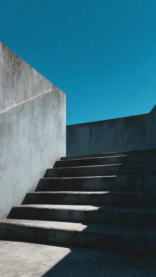 Minimalist Concrete Staircase with Dramatic Shadows and Deep Blue Sky 4K wallpaper for desktop and mobile - Pixbee