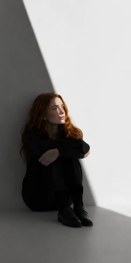 Sadie Sink Sitting in Shadowed Corner 4K wallpaper for desktop and mobile - Pixbee