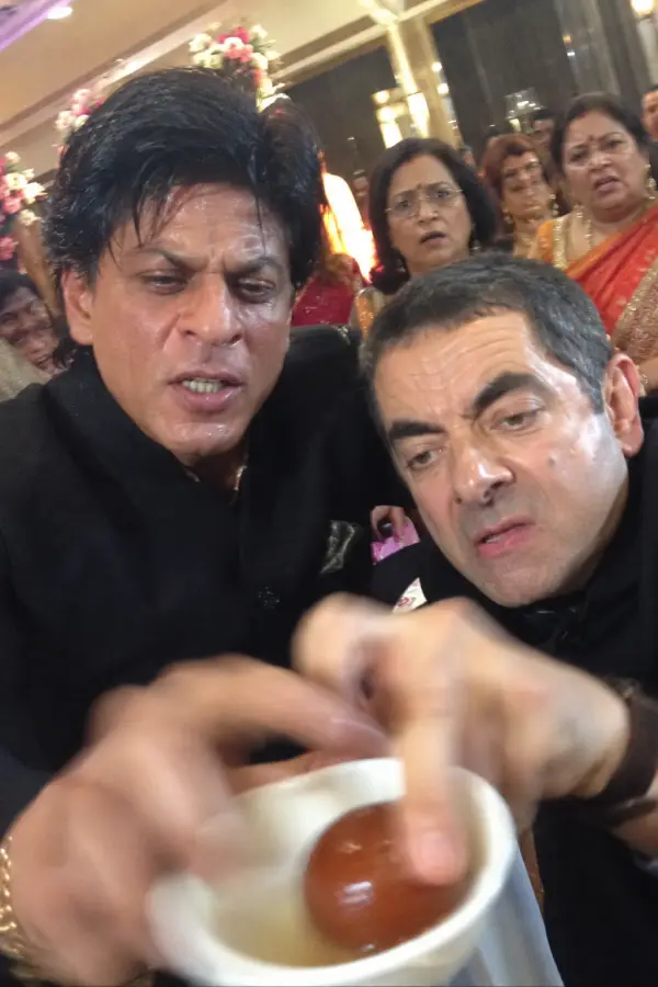 “Shah Rukh Khan and Mr. Bean fighting for the last gulab jamun like it decides the fate of humanity.” 4K wallpaper for desktop and mobile - Pixbee
