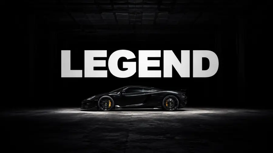 Sleek Black Sports Car Lit Underneath Large Bold White Typography Reading Legend 4K wallpaper for desktop and mobile - Pixbee